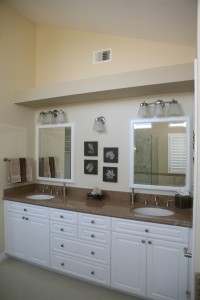The vanity of a bathroom with white cabinets.