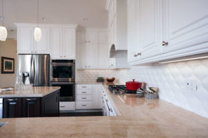 An updated kitchen with white cabinets, stainless steel appliances, and a kitchen island.