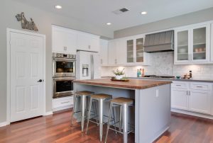A luxury kitchen with butcher block countertops and white shaker cabinets