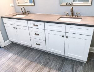 White cabinets with sinks and mirror in bathroom