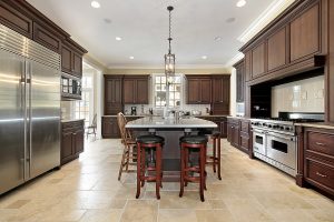 A large luxury kitchen with dark cabinets and a kitchen island.