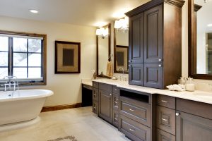 Bathroom with custom brown cabinetry and light lamps
