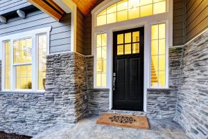 Front porch with stone siding and large, white-framed windows.
