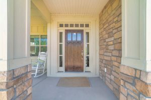 Dark wooden front door with transom window and side panels