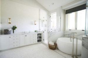 Modern bathroom with white cabinets, a bathtub and a shower