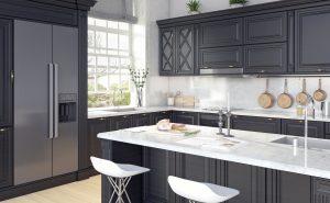 A remodeled kitchen with black cabinets and white marble countertops