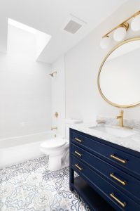 A white luxury bath room with blue cabinet and big mirror